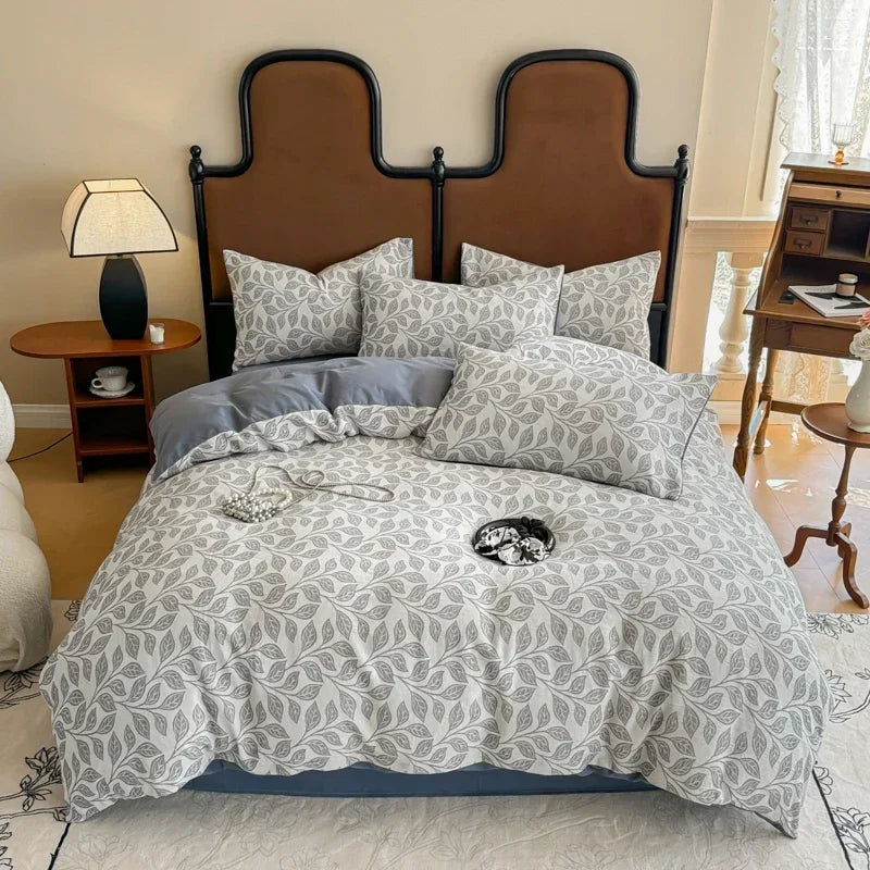 Bedroom with a bed featuring gray and white patterned bedding and pillows.