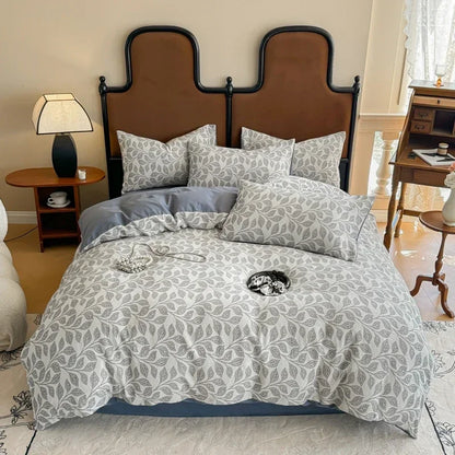 Bedroom with a bed featuring gray and white patterned bedding and pillows.