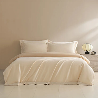 Beige bedding set on a bed in a minimalistic bedroom with a lamp and nightstand.