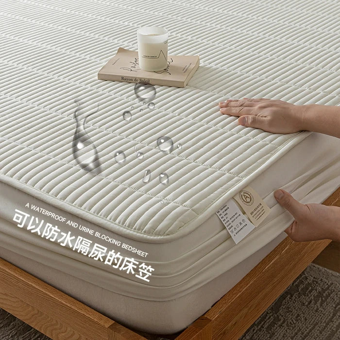 Bedding set with waterproof and urine-blocking feature on a bed, showing hands interacting with it.