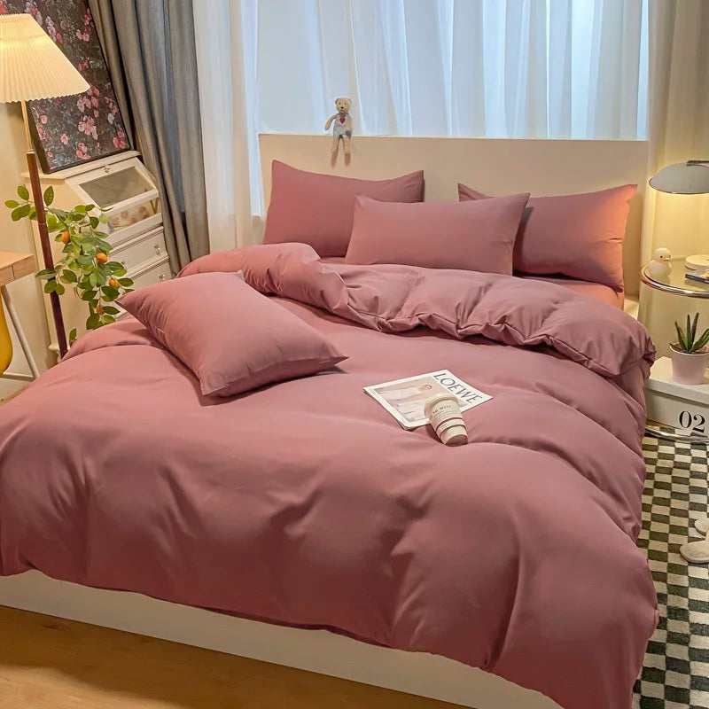 Bed with pink bedding in a bedroom setting with decor elements.