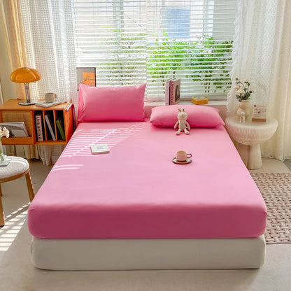 Pink bedspread on a bed in a bright room with a window and decor.