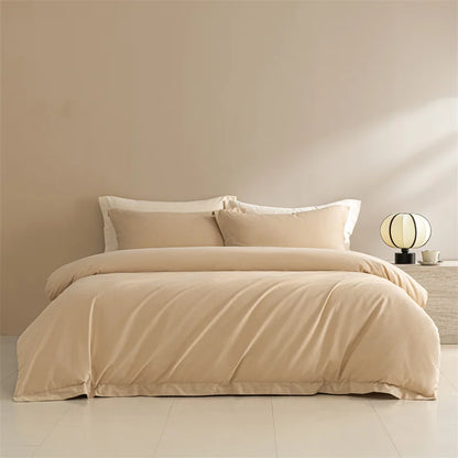 Beige bedding set on a bed in a minimalistic room with a lamp and decor items.