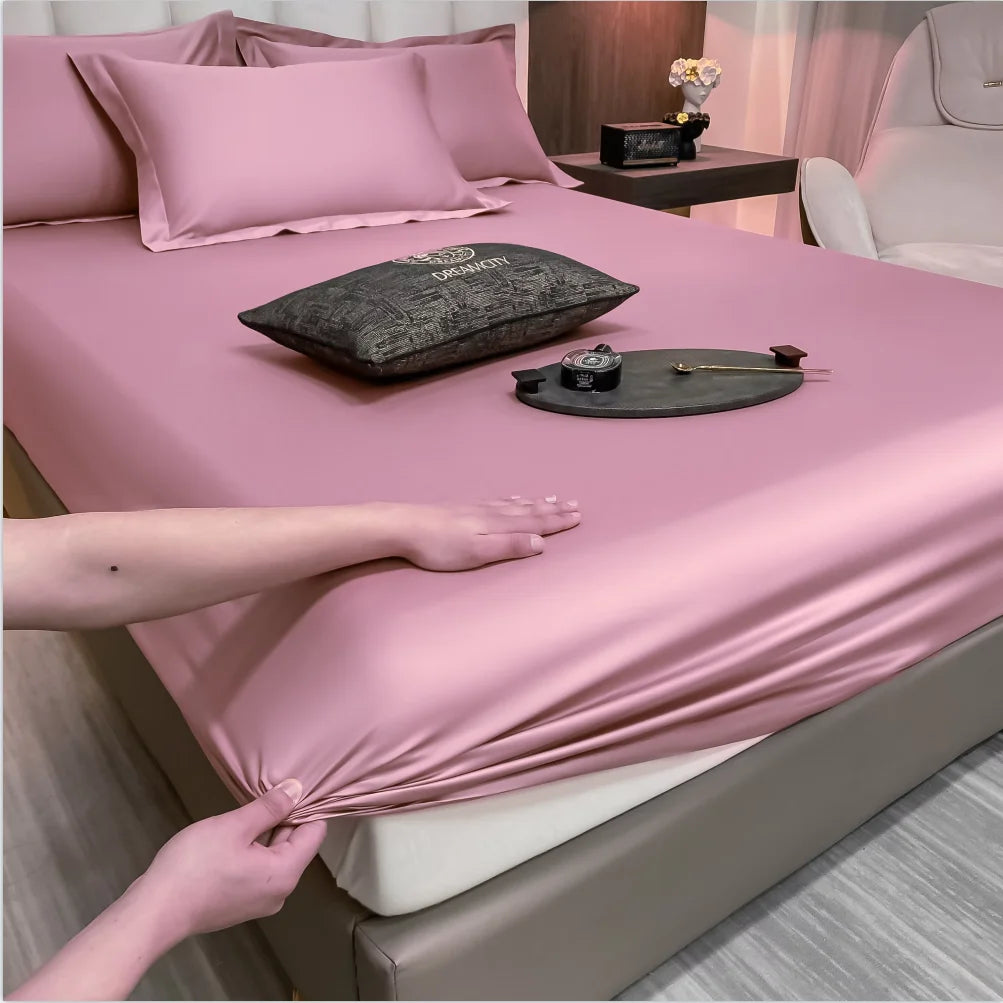 Person adjusting pink satin sheet on a bed with decorative items.