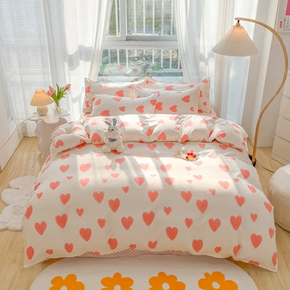 Heart-patterned bedding set in a bright bedroom with white curtains and a lamp.