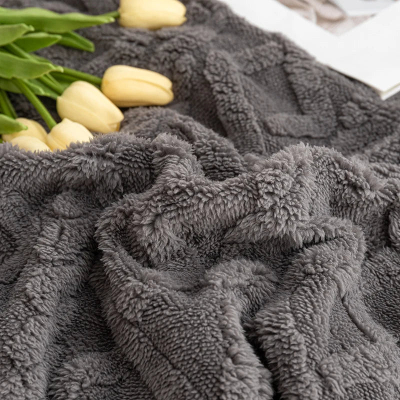 Gray textured blanket with yellow tulips and green leaves on a white background