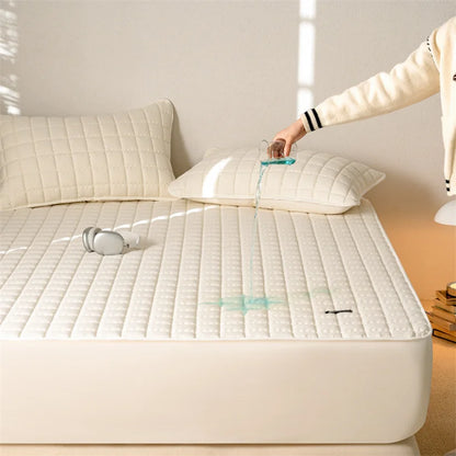 Person vacuuming a mattress with a white pillow and beige wall in the background