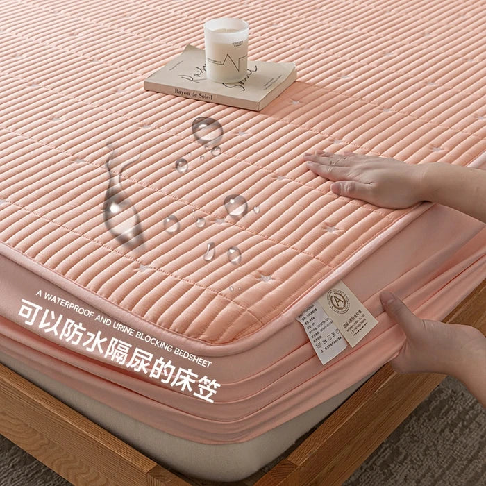 Pink waterproof bedsheet with a hand touching it, showing its texture and design.