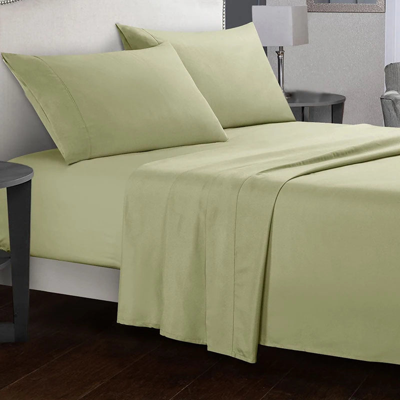 Green bed sheets and pillows on a bed in a bedroom setting.