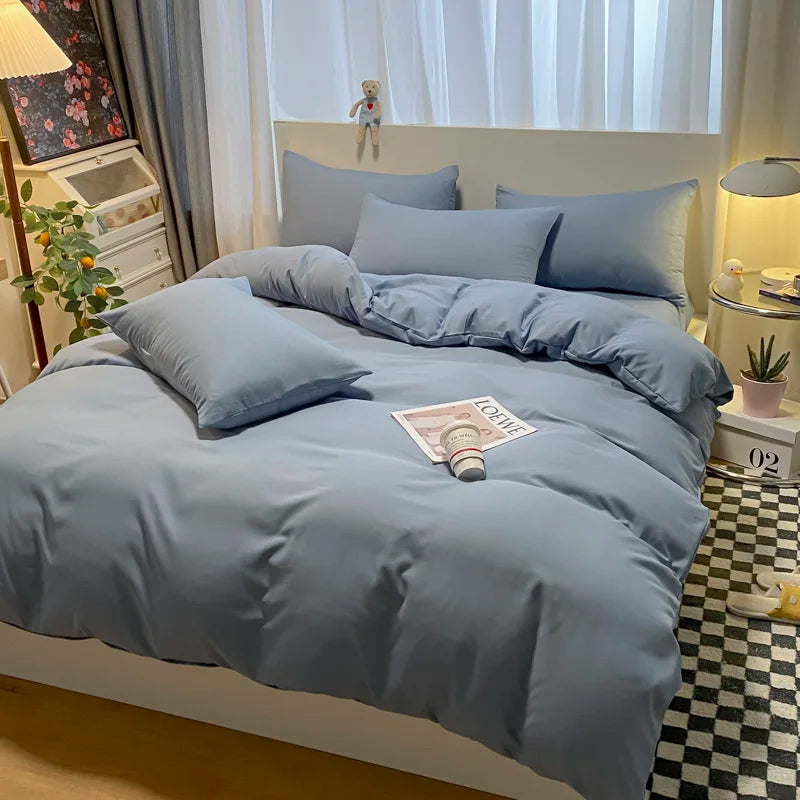 Blue bedding set on a bed in a bedroom with decor elements.