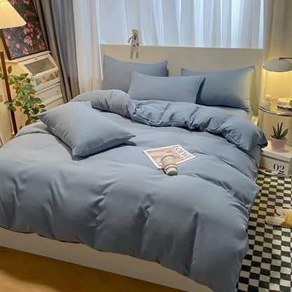 Blue bedding set on a bed in a bedroom with decor elements.