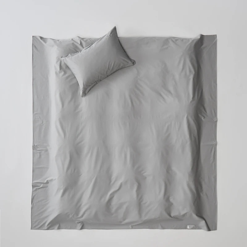 Light gray bedding set with a pillow on a white background