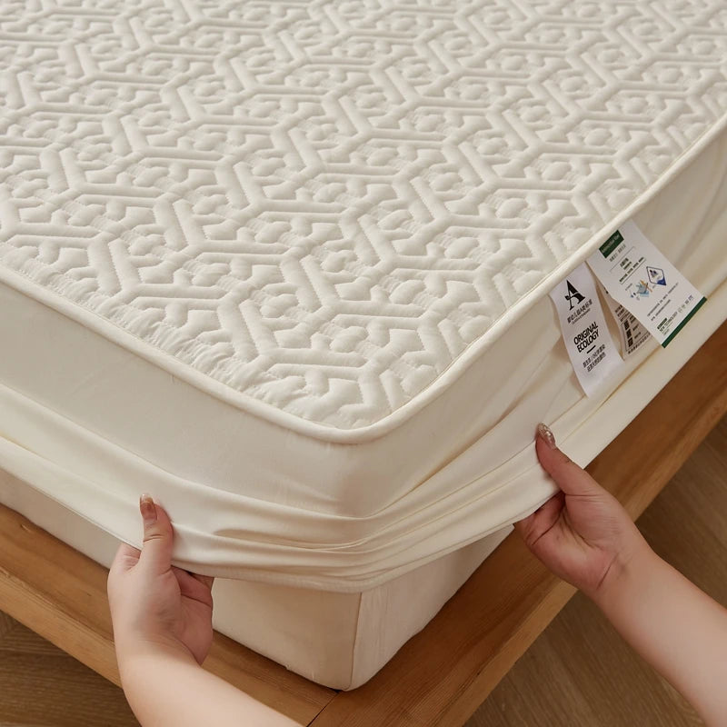 Person adjusting a fitted sheet on a mattress with a geometric pattern