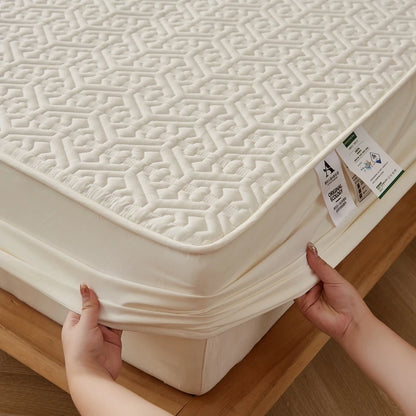 Person adjusting a fitted sheet on a mattress with a geometric pattern