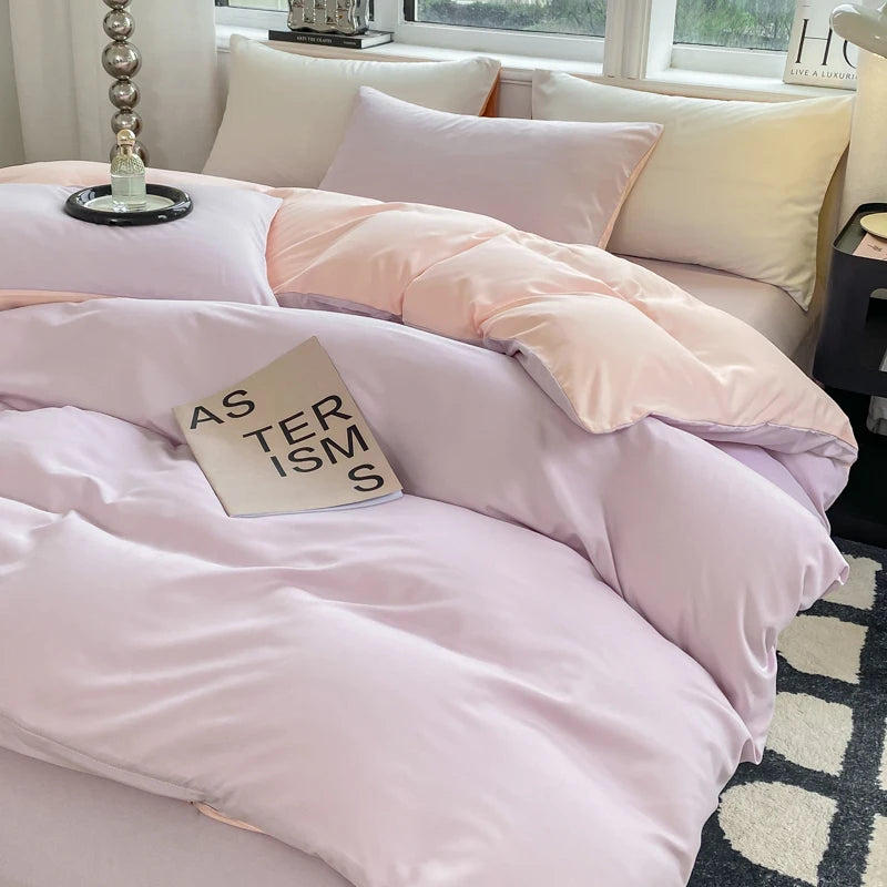 Pink and white bedding set on a bed with a book titled 'AS TERISMS' in a bedroom setting.