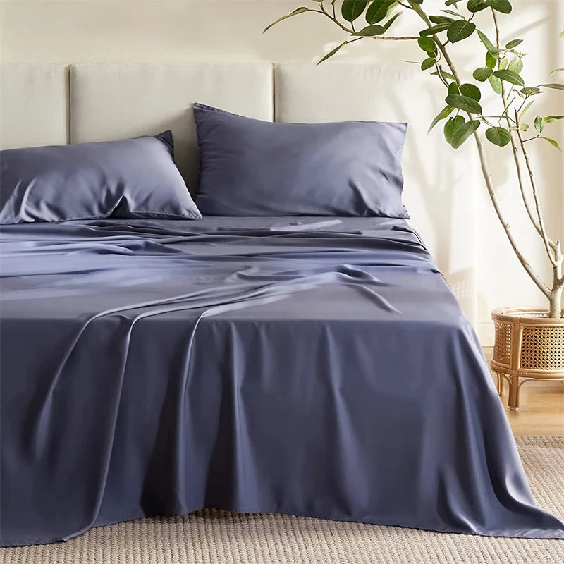 Navy blue bedding set on a bed in a bedroom with a plant and wooden side table.