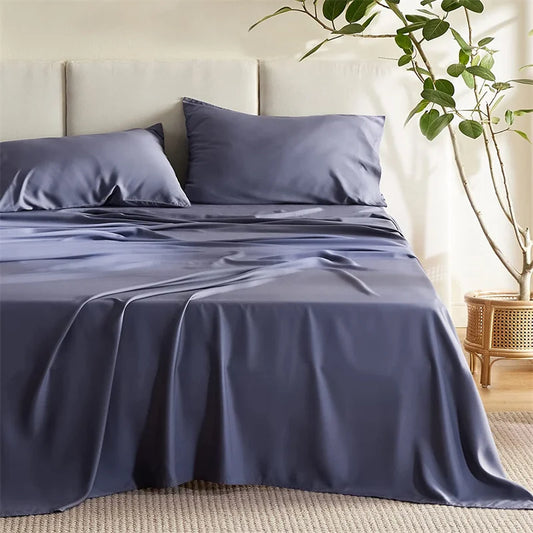 Navy blue bedding set on a bed in a bedroom with a plant and wooden side table.