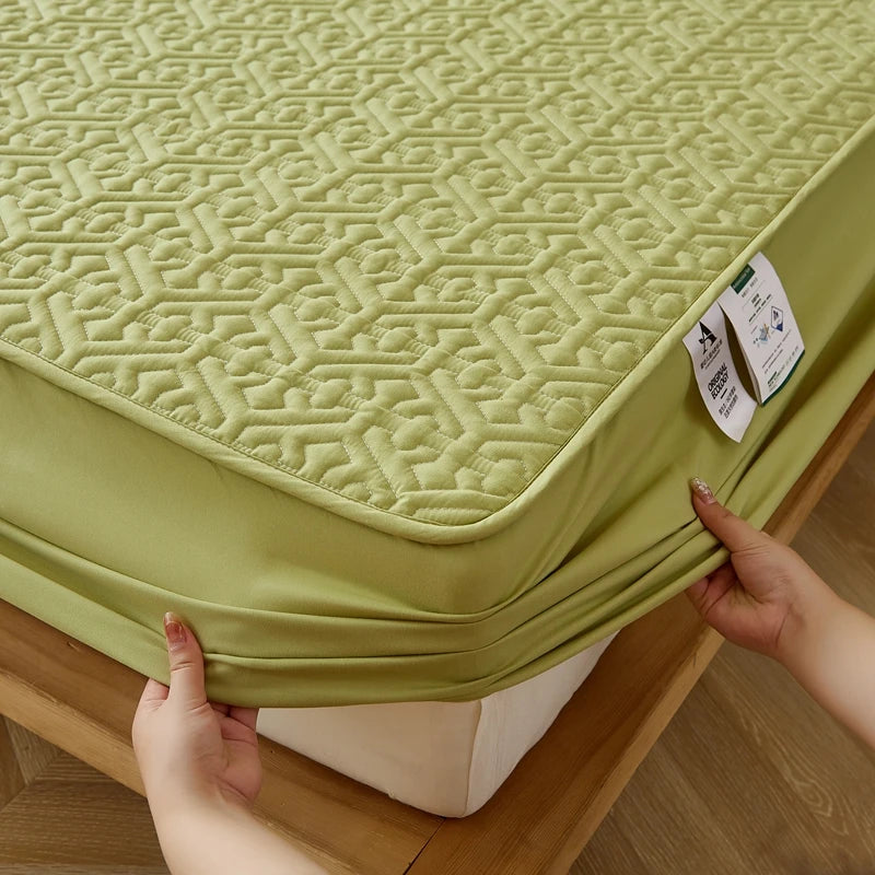 Green mattress cover with a geometric pattern being adjusted on a bed.