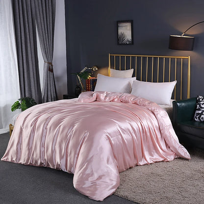 Bedroom with pink satin bedding and gold headboard