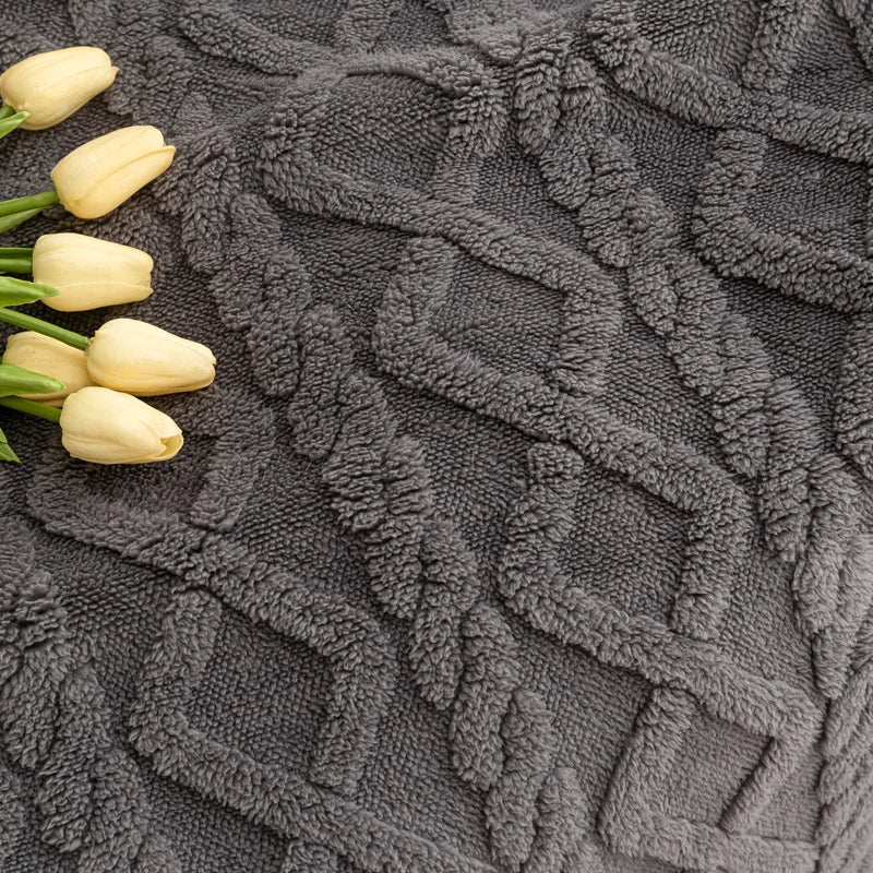 Gray textured rug with a floral pattern and white tulips on a dark surface