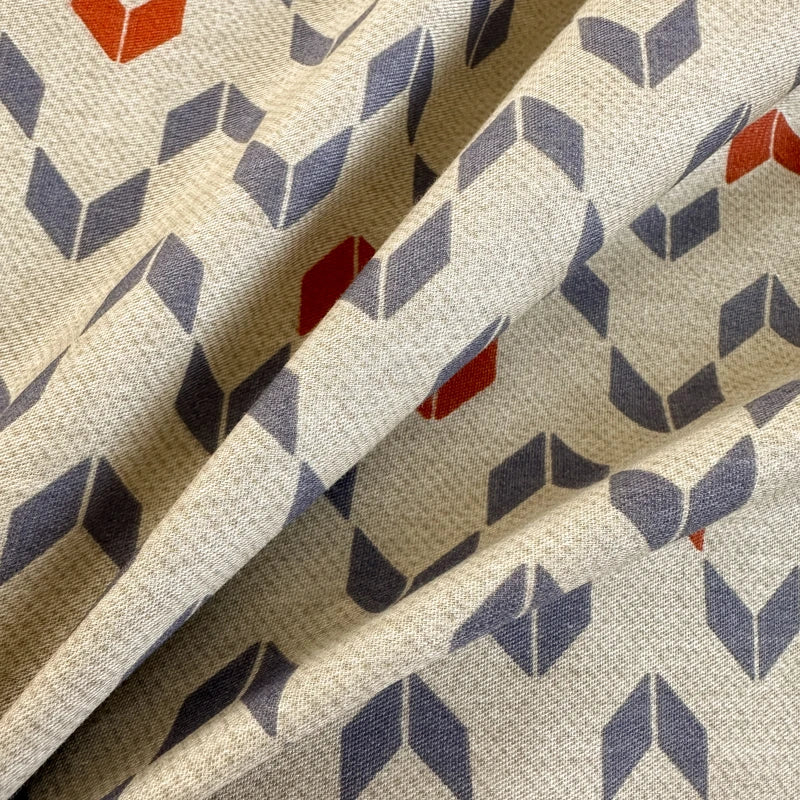 Close-up of fabric with geometric pattern in red, blue, and beige.