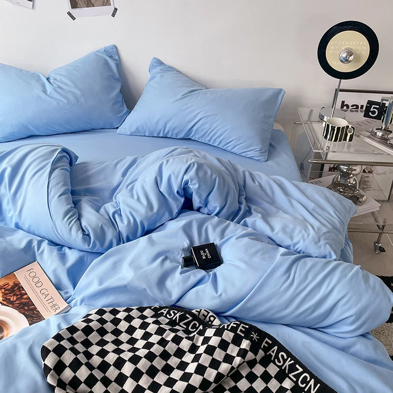 Blue bedding set on a bed with a nightstand in the background