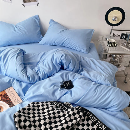 Blue bedding set on a bed with a nightstand in the background