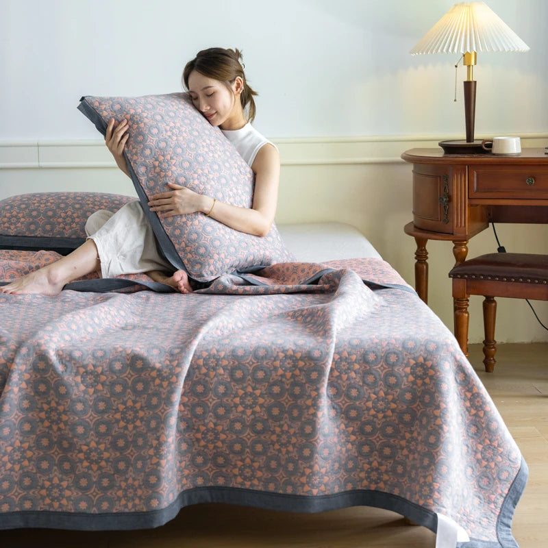Woman holding a patterned pillow on a bed in a room with a wooden desk and lamp.