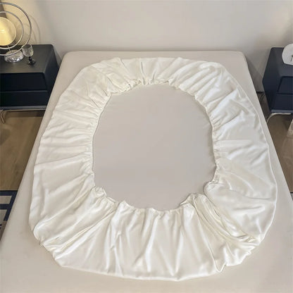 White fitted sheet on a bed in a bedroom setting