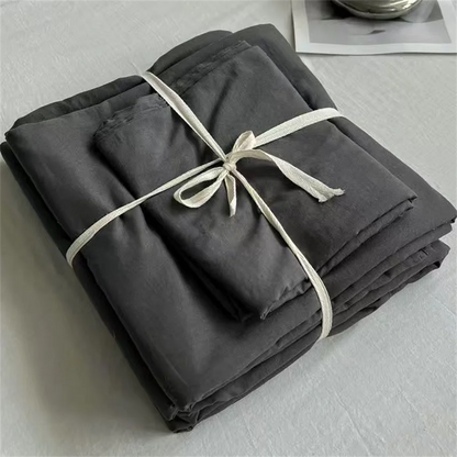 Folded dark gray fabric with a white ribbon on a light gray background