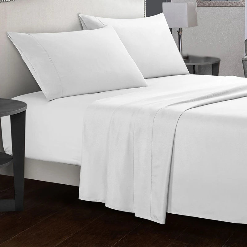 White bed sheets and pillows on a neatly made bed in a bedroom setting.