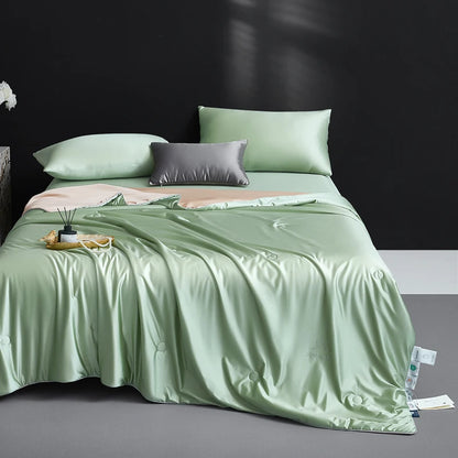 Bed with light green bedding and pillows against a dark wall