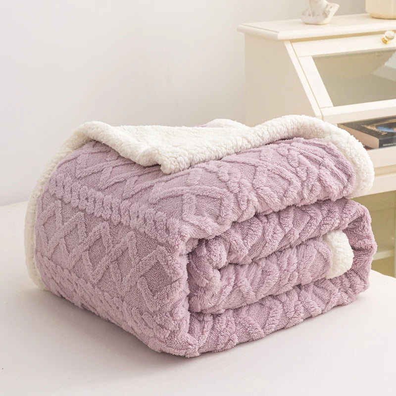 Folded pink blanket with white trim on a light surface