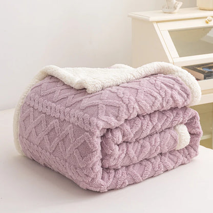 Folded pink blanket with white trim on a light surface