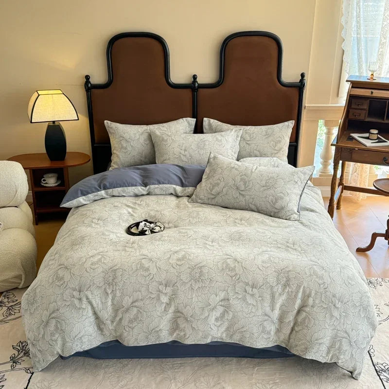 Bedroom with a large bed featuring patterned bedding and pillows, surrounded by furniture.