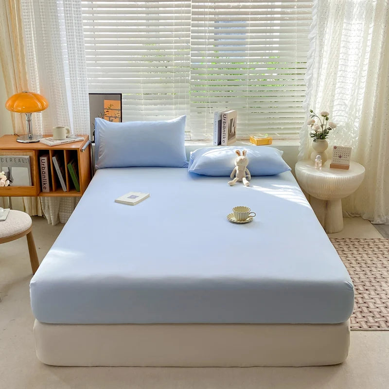 Bed with light blue mattress cover in a bright room with window blinds and decor.