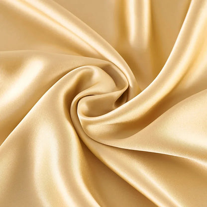 Close-up of beige satin fabric with folds