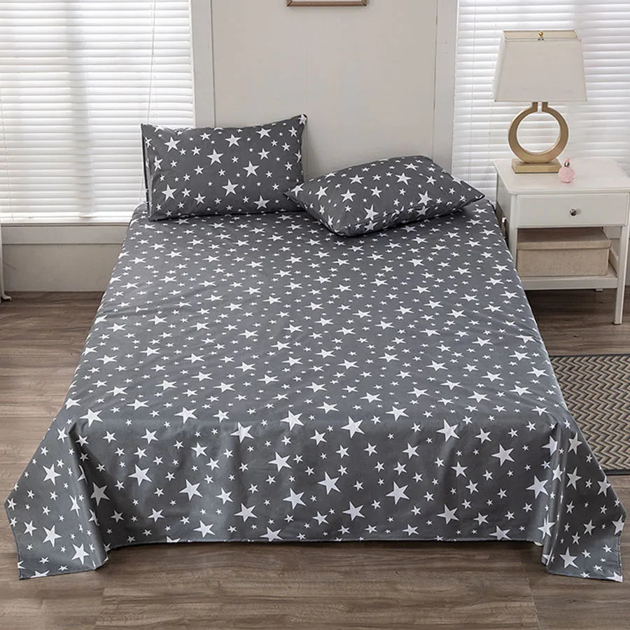 Gray bedspread with star pattern on a bed in a bedroom setting.