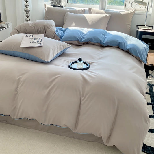 Beige bedspread with blue accents on a bed in a bedroom setting.