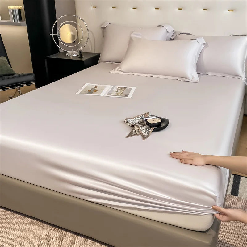 Person adjusting a fitted sheet on a bed in a bedroom setting.