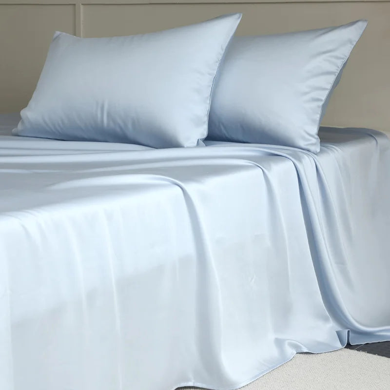 Light blue satin sheet set on a bed with pillows.
