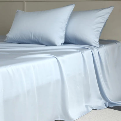Light blue satin sheet set on a bed with pillows.