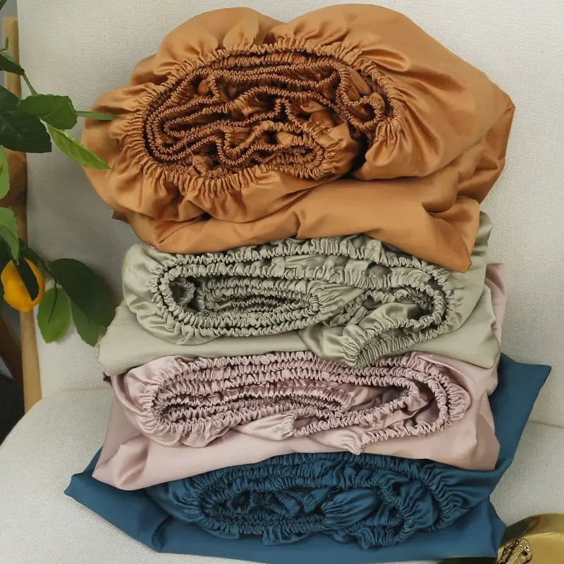 Stack of folded fabric swatches in brown, beige, pink, and blue on a white surface.