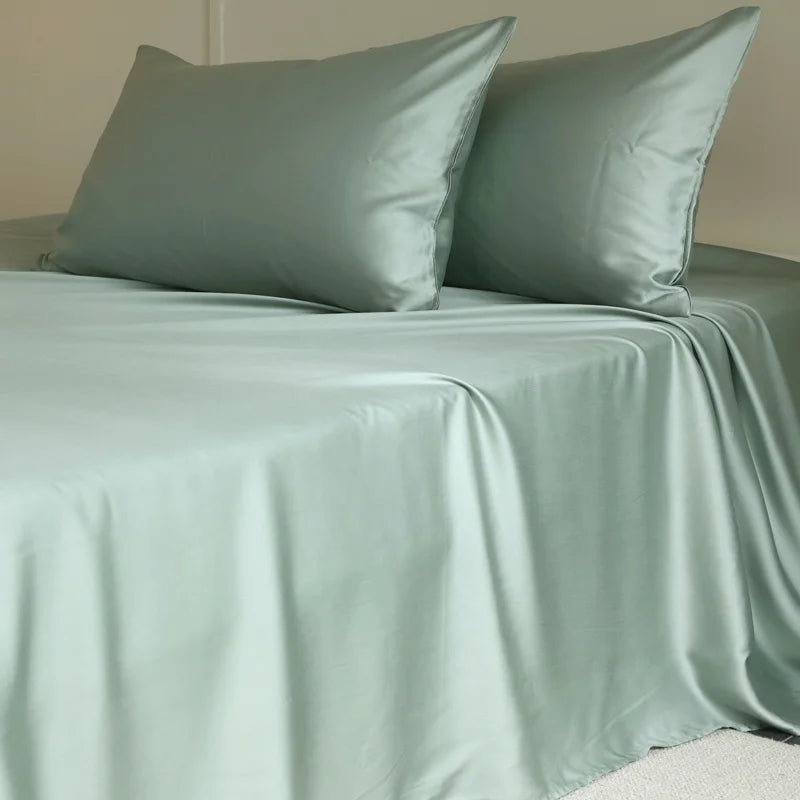 Light green satin sheet set on a bed with matching pillows.