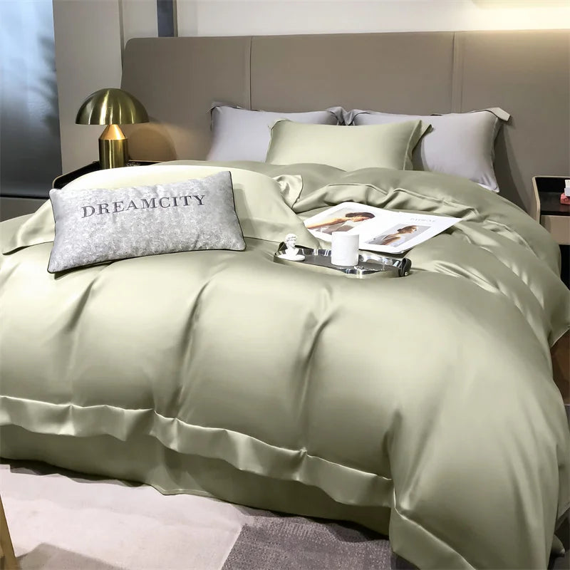 Bed with green bedding and 'Dreamcity' pillow in a bedroom setting