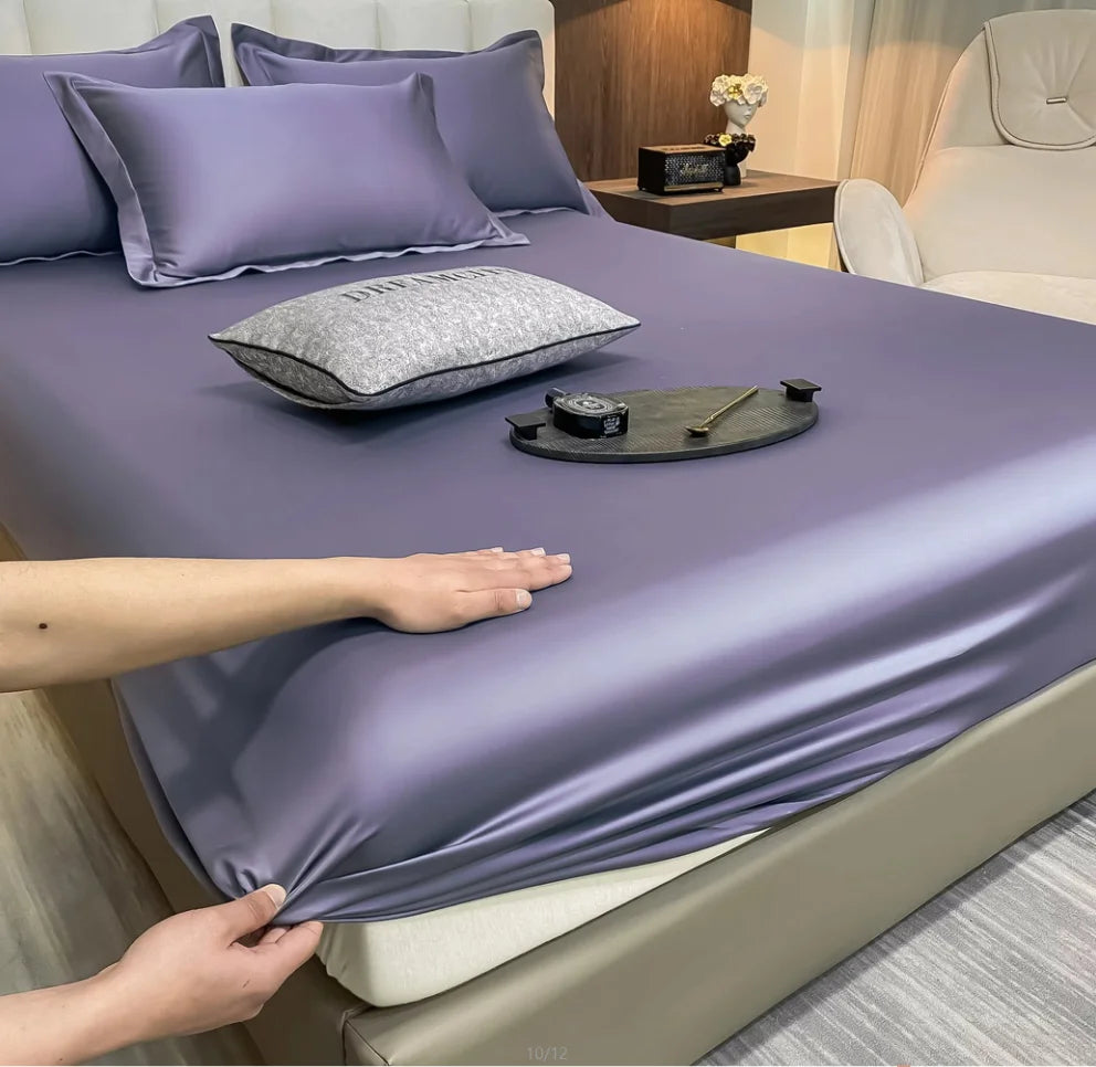 Purple satin sheet set on a bed with a person adjusting it.