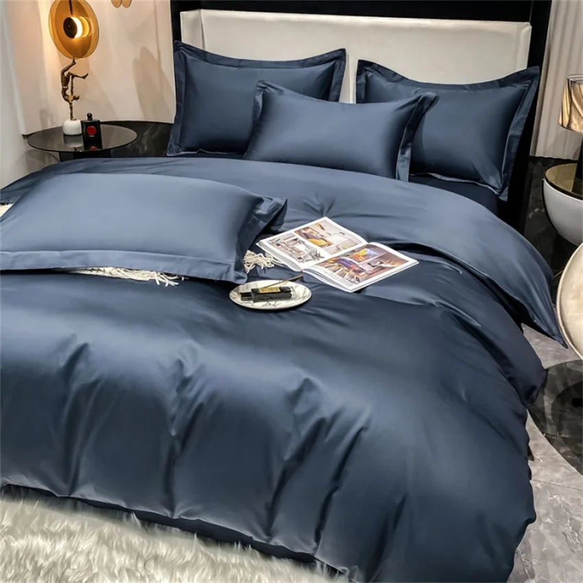Blue bedding set on a bed with a nightstand and decor items in the background.