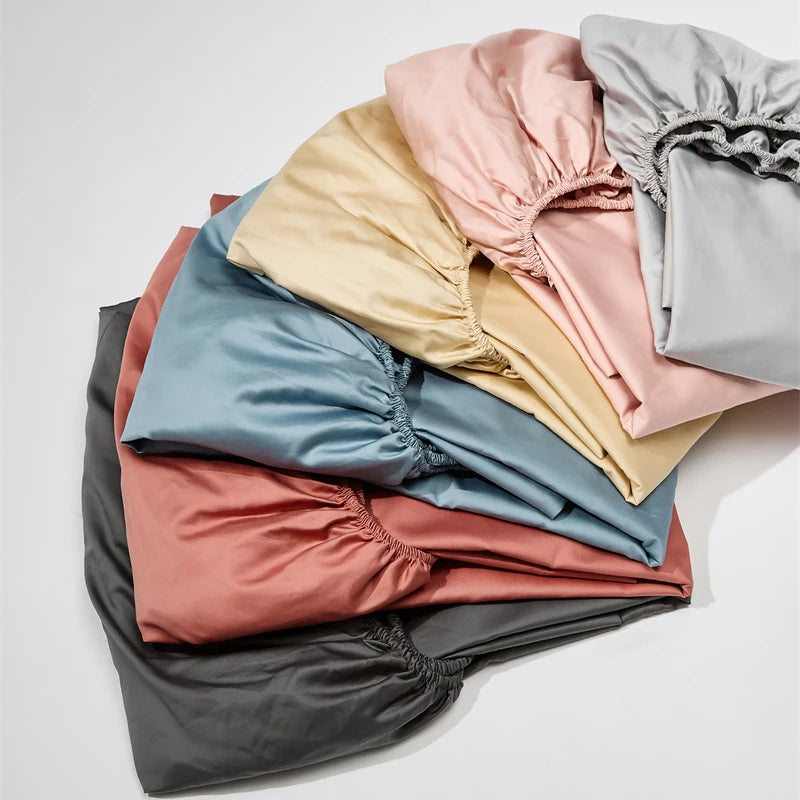 Stack of folded colorful satin sheets on a light gray background