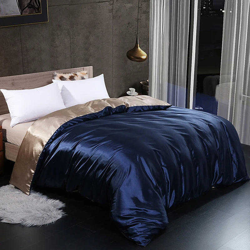 Bed with navy satin duvet cover and white pillows in a modern bedroom setting.