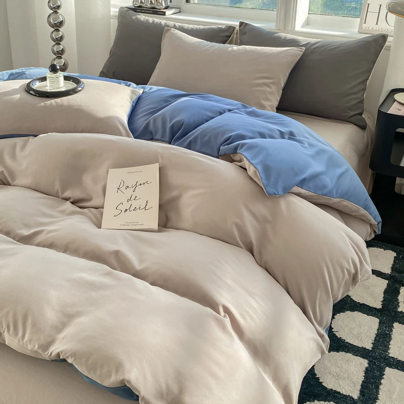 Neatly made bed with beige and blue bedding, a book titled 'Raison de Soleil' on the pillow.